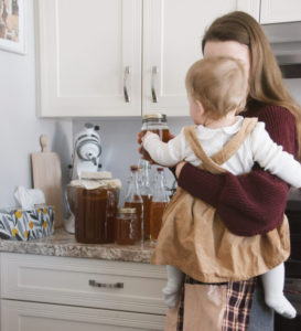 Holding my daughter in our kitchen, while doing one of my homemaking tasks.