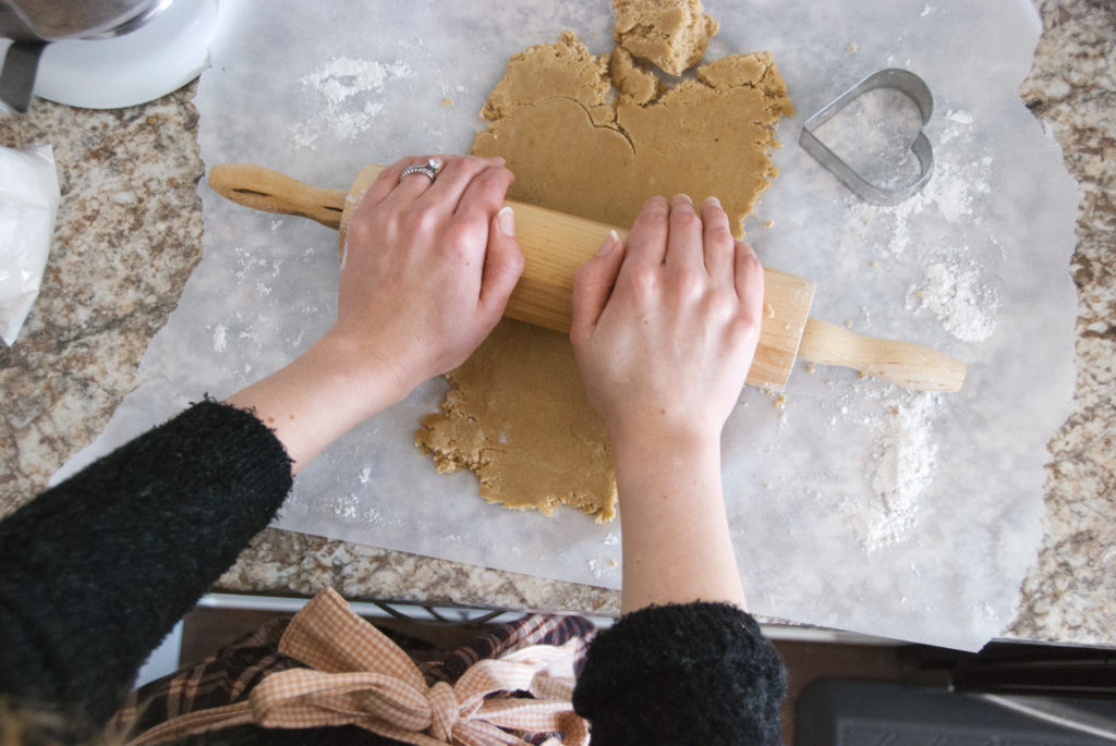 Rolling out cookie dough to make gluten free sugar cookies